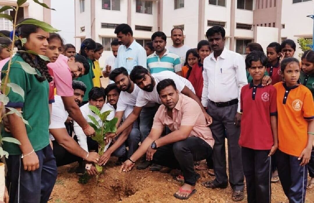 Group community effort planting saplings with youth and volunteers.