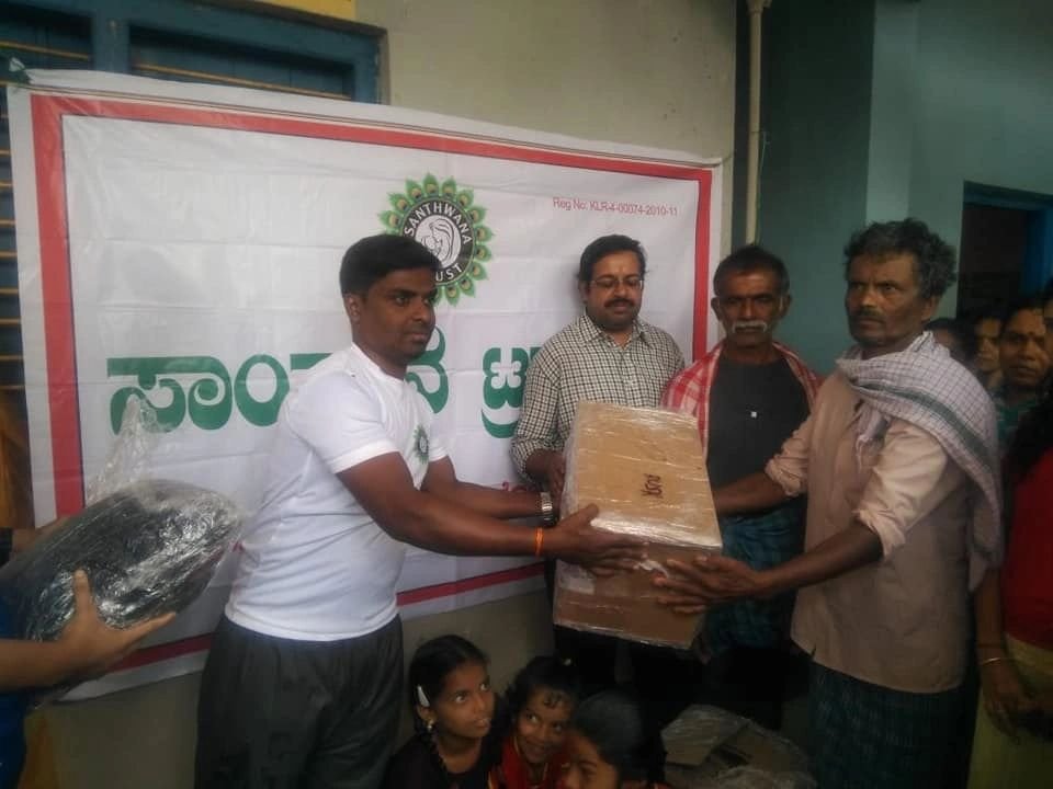Volunteers distributing food grains and essential kits.